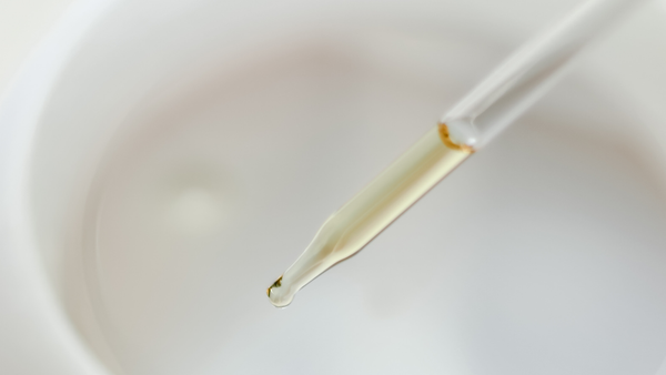close up pipette with golden yellow cbd oil